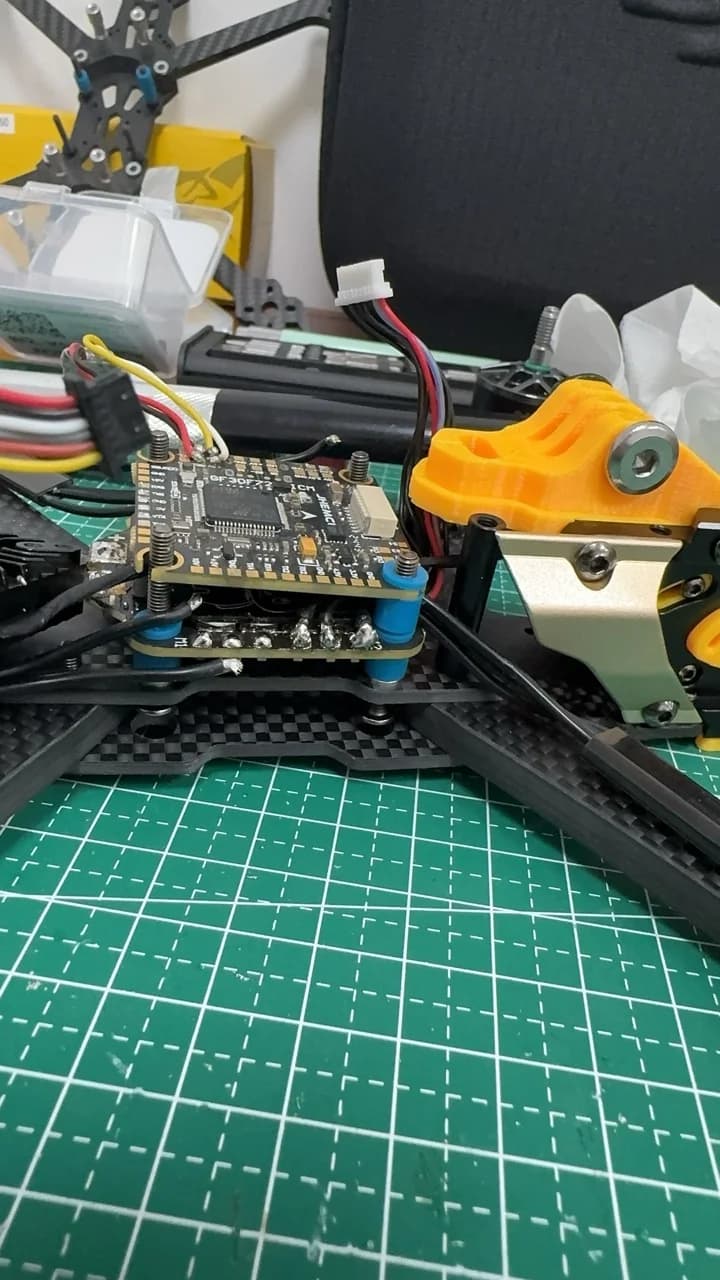 Close view of the flight controller stack, wiring and camera mount inside an FPV drone